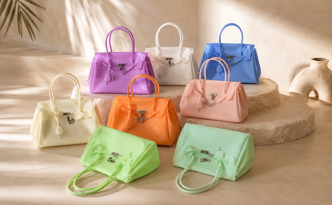 Eight JellyB totes in different shades on stone plinths, in natural light